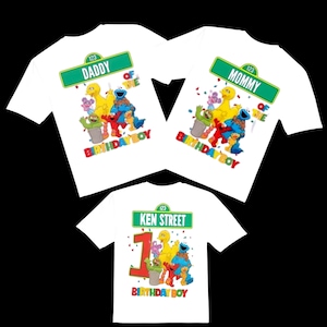 May include: Three white t-shirts with Sesame Street characters. One shirt says "Daddy" and "Birthday Boy", another says "Mommy" and "Birthday Boy", and the third says "1" and "Birthday Boy". All shirts have colorful graphics.
