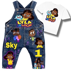 May include: Denim overalls and a white t-shirt featuring characters from "Lyla in the Loop." The overalls have colorful graphics, the name "Sky," and the number "1." The t-shirt displays the show's logo and characters.