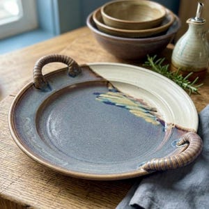 Puede incluir: Un juego de tres tazas de cerámica con un acabado mate moteado. Las tazas son en tonos crema, gris claro y gris oscuro. Cada taza tiene un diseño simple y minimalista, ideal para café o té.