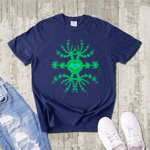 May include: Navy blue t-shirt featuring a vibrant green and turquoise fractal design. The graphic is centered on the shirt, creating a striking visual contrast. The shirt is paired with blue jeans and white sneakers, suggesting a casual style.