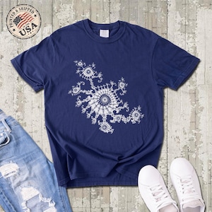 May include: A navy blue short-sleeve t-shirt featuring a white intricate fractal pattern printed on the center of the chest. The shirt has a crew neckline and a standard fit, showcasing a complex geometric design with repeating spiral elements.