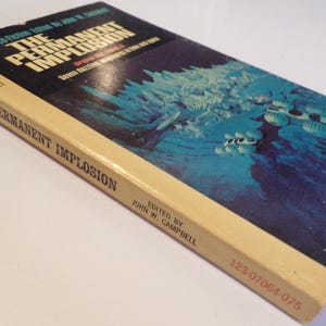 Może przedstawiać: Zabytkowa książka w miękkiej oprawie zatytułowana "The Permanent Implosion" z niebiesko-białą ilustracją na okładce. Książka ma grzbiet w kolorze kremowym i widoczny jest tekst "Science Fiction".