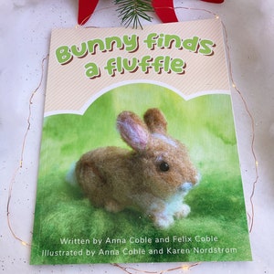 May include: A children's book titled "Bunny finds a fluffle" with a brown and white bunny on the cover. The book has a green background and the title is in orange and yellow.