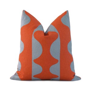 May include: Orange and light blue throw pillow with a geometric pattern.