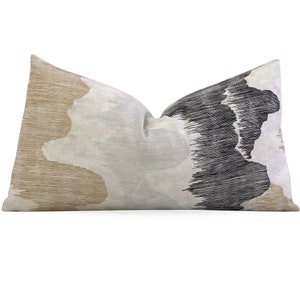 May include: A decorative throw pillow with a beige, gray, and black abstract pattern. The pattern features a series of overlapping, organic shapes.
