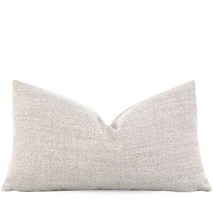 May include: A beige throw pillow with a subtle textured pattern.