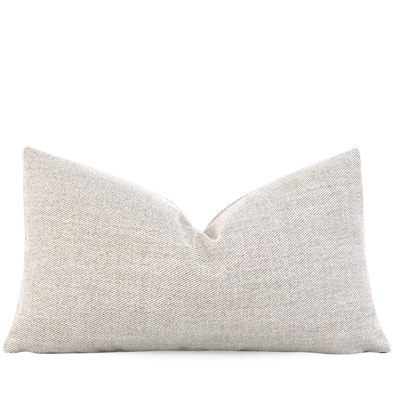 May include: A beige throw pillow with a subtle textured pattern.