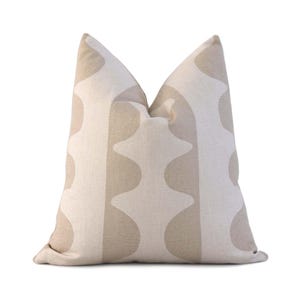 May include: A beige throw pillow with a geometric pattern of light brown abstract shapes.