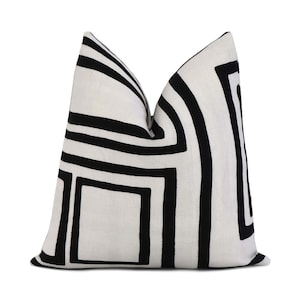 May include: Black and white geometric patterned throw pillow with a white background and black lines.