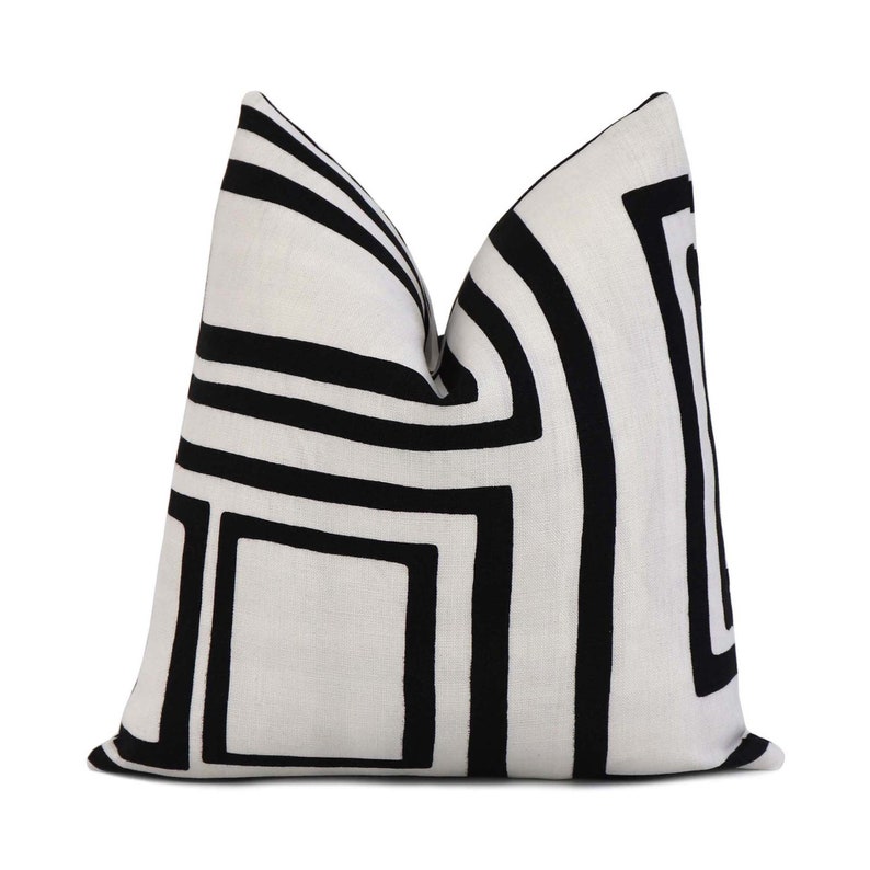 May include: Black and white geometric patterned throw pillow with a white background and black lines.