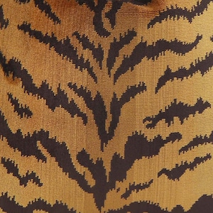 May include: Close-up of a fabric with a brown and black tiger stripe pattern.