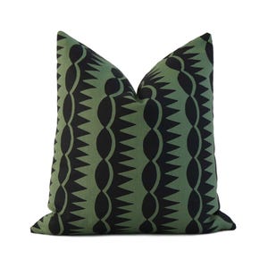 May include: A green and black patterned throw pillow with a geometric design. The pillow is made of a soft, comfortable fabric and is perfect for adding a touch of style to any room.