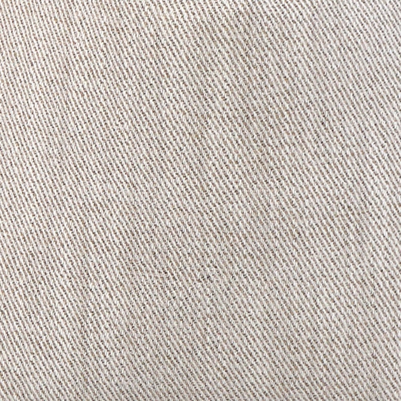 May include: Close-up of a beige fabric with a diagonal weave pattern. The fabric has a subtle texture and a slightly rough feel.