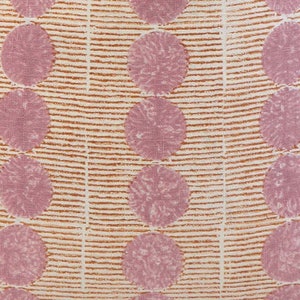 May include: A white fabric with a repeating pattern of pink circles and orange stripes. The circles have a textured appearance.