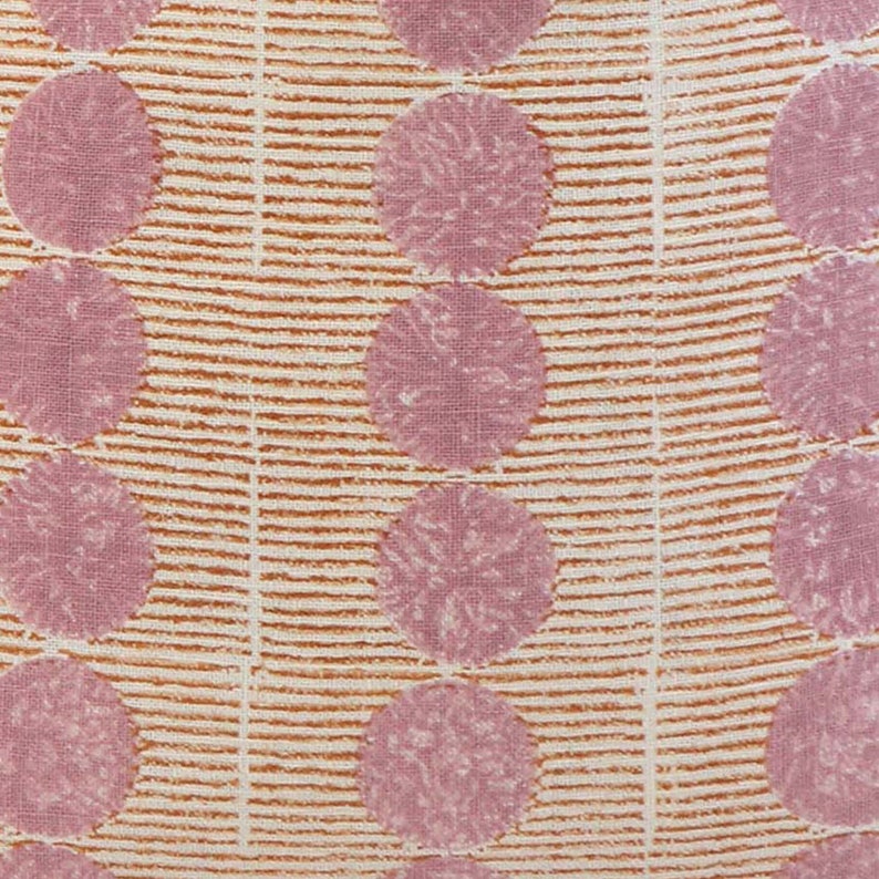 May include: A white fabric with a repeating pattern of pink circles and orange stripes. The circles have a textured appearance.