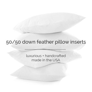 May include: A stack of four white down feather pillow inserts. The pillows are arranged in a pyramid shape. The text "50/50 down feather pillow inserts" is written above the pillows. Below the pillows, the text "luxurious + handcrafted made in the USA" is written.