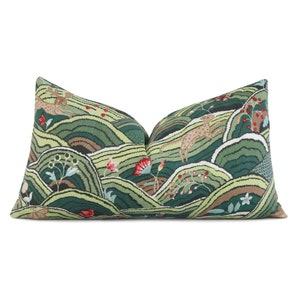 May include: A green and brown patterned throw pillow with a design of stylized hills, flowers, and animals. The pillow is rectangular and has a soft, plush texture.