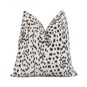 May include: A white throw pillow with a black and white geometric pattern. The pattern is made up of small, irregular shapes.