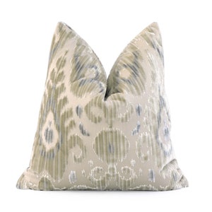 May include: A decorative throw pillow with a cream background and a blue and green ikat pattern.