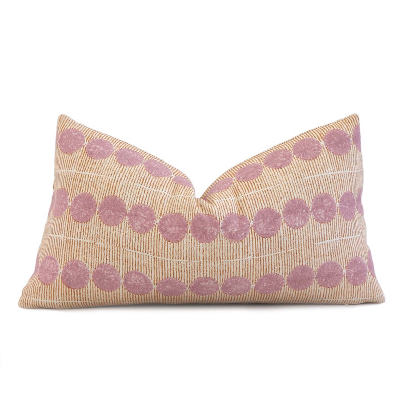 May include: A rectangular pillow with a geometric pattern. The pillow is made of a soft, textured fabric and features a repeating pattern of pink circles on a beige background.