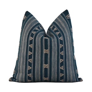 Puede incluir: Coj&iacute;n de tiro azul teal con un patr&oacute;n geom&eacute;trico de tri&aacute;ngulos y l&iacute;neas doradas.