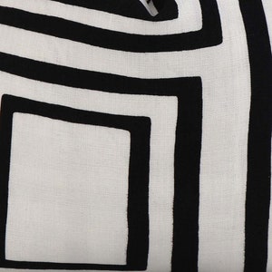 May include: White fabric with a black geometric pattern of overlapping squares. The pattern is created with thick black lines.