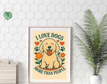 May include: A framed print with the text "I LOVE DOGS MORE THAN PEOPLE" and a cartoon dog illustration. The dog is light yellow with a happy expression, surrounded by hearts, paw prints, and flowers. The print has a beige background.