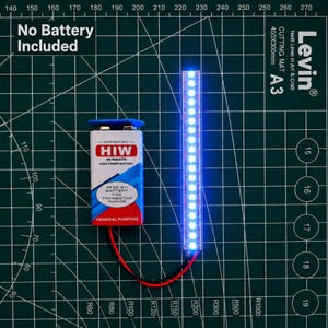 Op de afbeelding: Een rechthoekige 9V HI-WATE batterij met een rood, wit en blauwe behuizing, verbonden via zwarte en rode draden met een verticale strip van helderblauwe LED-lampjes. De tekst op de batterij luidt HI-WATE, 6F22 9V BATTERY FOR TRANSISTOR RADIOS.