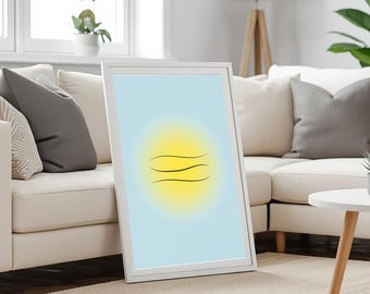 May include: A framed art print featuring a minimalist design. The artwork has a light blue background with a yellow sun-like shape and three curved black lines. The frame is white, and the print is leaning against a white sofa.