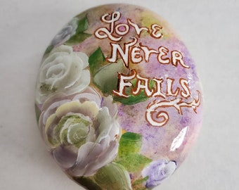 Inspirational hand painted rock with soft roses, elegantly painted Love Never Fails with roses on a large natural stone, unique garden rock