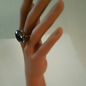 Puede incluir: Un anillo de plata con una piedra ovalada azul.