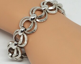 Puede incluir: Pulsera de plata con un diseño de cadena de eslabones con círculos entrelazados y cuentas redondas.