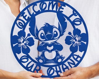May include: A blue metal sign with the words "WELCOME TO OUR OHANA" encircling a cartoon character. The sign is held by a couple, and features floral cutouts.