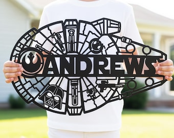 May include: Black metal sign in the shape of the Millennium Falcon, with the name "ANDREWS" cut out in the center. The sign features iconic Star Wars imagery, including the Rebel Alliance symbol and Darth Vader's helmet.