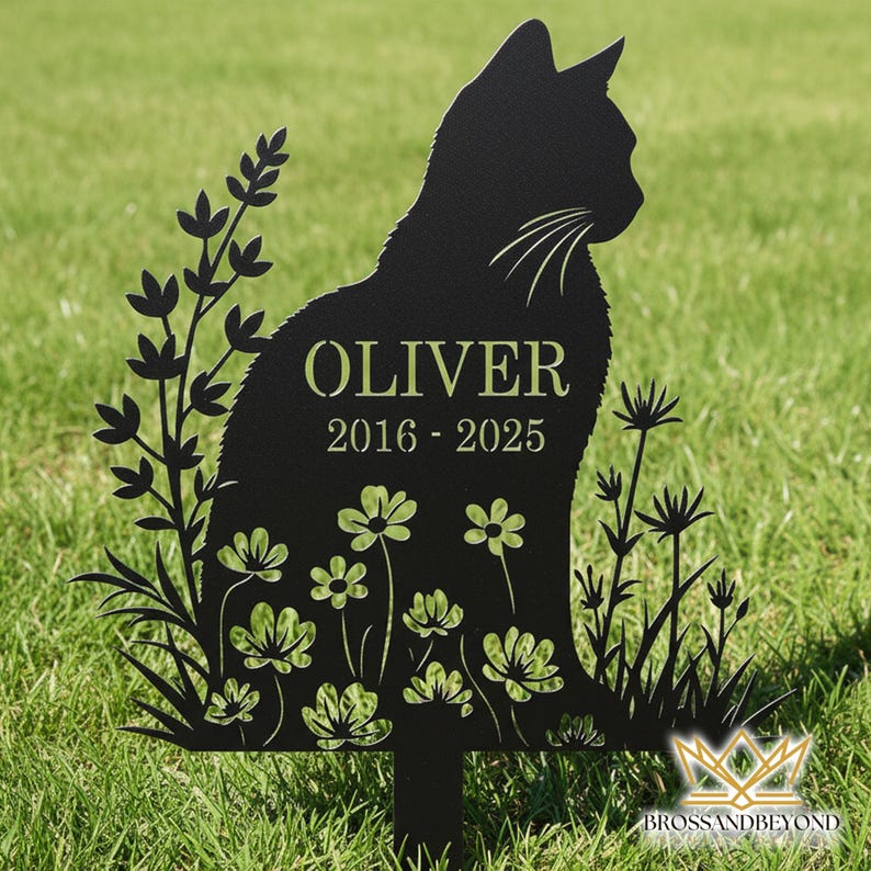 Puede incluir: Estaca de jard&iacute;n de metal negro con silueta de gato con el nombre "OLIVER" y las fechas "2016-2025" recortadas. El gato est&aacute; rodeado de recortes florales y vegetales, con un logotipo en la parte inferior.