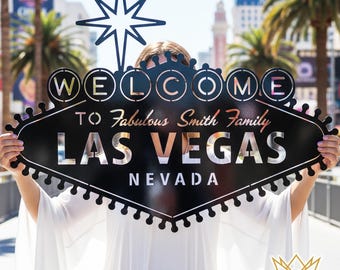 Könnte beinhalten: Schwarzes Metallschild von Las Vegas mit dem Text "WELCOME TO Fabulous Smith Family LAS VEGAS NEVADA". Das Schild hat einen Stern oben und wird vor einer Person hochgehalten. Das Schild ist ein dekorativer Gegenstand.