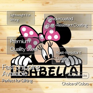 May include: A black metal Minnie Mouse-themed sign with the name "ISABELLA" cut out. The sign features a pink bow with white polka dots and is made of premium quality steel with a rust-resistant coating. The sign has pre-drilled holes.