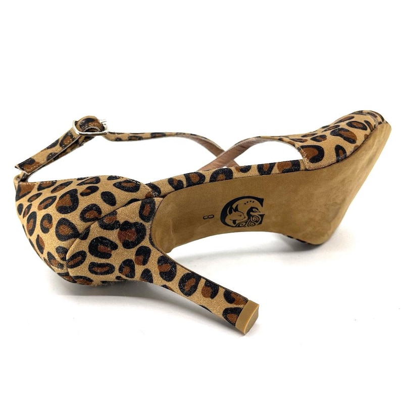 K&ouml;nnte beinhalten: Ein Paar High-Heels mit Leopardenmuster. Die Schuhe haben einen Kn&ouml;chelriemen. Der Absatz ist etwa 7,6 cm hoch. Die Sohle des Schuhs ist hellbraun.