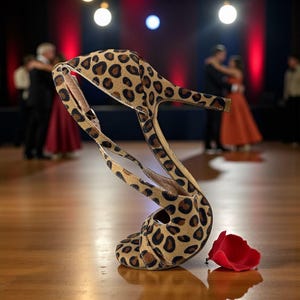 K&ouml;nnte beinhalten: Ein Tanzschuh mit hohem Absatz und Leopardenmuster, mit einem schlanken Absatz und Kn&ouml;chelriemen. Ein einzelnes rotes Rosenblatt liegt auf dem Holzboden neben dem Schuh. Der Hintergrund zeigt einen Ballsaal mit T&auml;nzern.