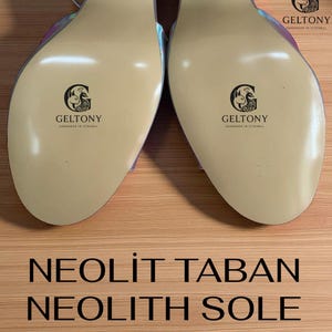 K&ouml;nnte beinhalten: Nahaufnahme der Sohlen von zwei High-Heels. Die Sohlen sind hellbeige mit dem Markennamen "GELTONY" und "HANDMADE IN ISTANBUL" aufgedruckt. Der Text "NEOLITH SOLE" ist ebenfalls sichtbar.