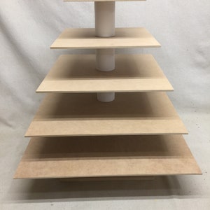 May include: A five-tier cake stand made of wood with a white base. Each tier is a square piece of wood.