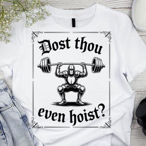 Pode incluir: Camiseta branca com uma ilustração em preto e branco de um cavaleiro levantando uma barra. O texto "Dost thou even hoist?" é exibido acima e abaixo da imagem do cavaleiro, dentro de uma moldura decorativa.
