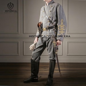 以下が含まれることがあります： 金色のアクセントが付いたグレーの南北戦争の制服。ダブルブレストのジャケット、ズボン、背の高い黒いブーツが含まれています。制服の袖には金の刺繍が施され、剣とベルトが付属しています。「HISTORICAL COSTUME ERA」の文字が見えます。