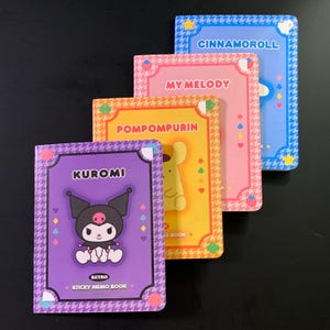 May include: Four colorful sticky memo books with cartoon characters. The books are labeled "Kuromi", "Pompompurin", "My Melody", and "Cinnamoroll". Each book has a different color scheme and design, with a retro style.