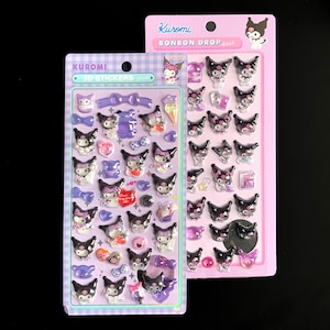 May include: Two sticker sheets featuring 3D stickers of the character Kuromi. The stickers are black, white, and purple, with various designs including bows, hearts, and ice cream cones. The packaging is pink and purple.