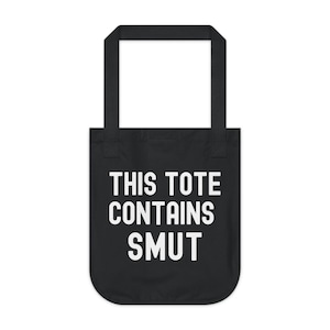 Pode incluir: Bolsa tote preta com texto branco que diz "THIS TOTE CONTAINS SMUT". A bolsa tem formato retangular com uma al&ccedil;a na parte superior, adequada para transportar itens. O design &eacute; simples e arrojado.