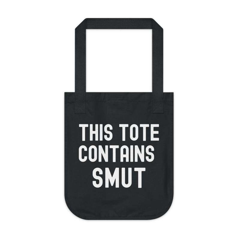 Pode incluir: Bolsa tote preta com texto branco que diz "THIS TOTE CONTAINS SMUT". A bolsa tem formato retangular com uma al&ccedil;a na parte superior, adequada para transportar itens. O design &eacute; simples e arrojado.