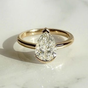 Pear Cut Moissanite Ring: 14K Yellow Gold Bezel Solitaire