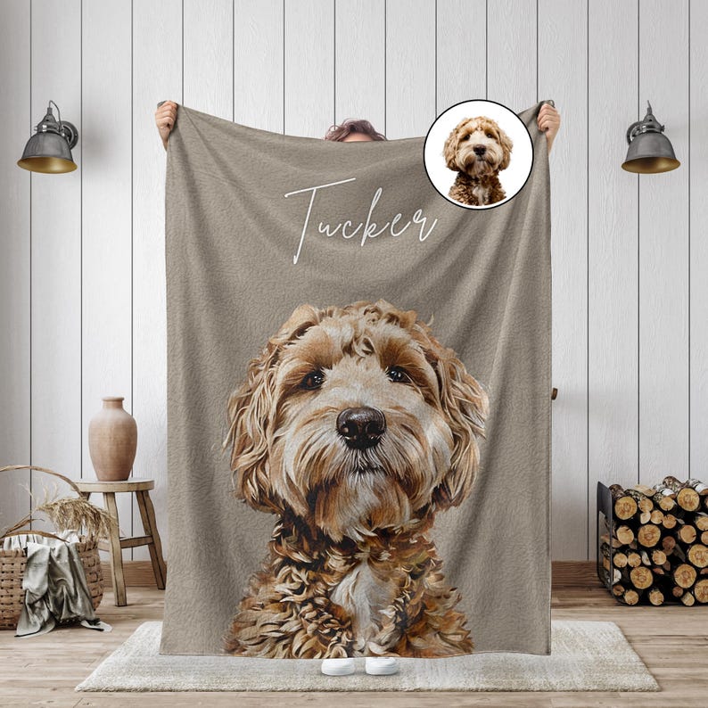 K&ouml;nnte beinhalten: Eine beige Decke mit einem detaillierten Portr&auml;t eines Hundes mit braunem und cremefarbenem Fell. Der Name des Hundes, "Tucker", ist in Schreibschrift &uuml;ber dem Gesicht des Hundes geschrieben. Ein kleineres kreisf&ouml;rmiges Bild des Hundes befindet sich in der oberen rechten Ecke.