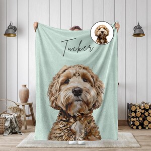 K&ouml;nnte beinhalten: Eine hellgr&uuml;ne Decke mit einem detaillierten Portr&auml;t eines Hundes mit braunem und cremefarbenem Fell. Der Name des Hundes, "Tucker", ist in Schreibschrift oben geschrieben. Ein kleineres Bild des Hundes befindet sich in der oberen rechten Ecke.
